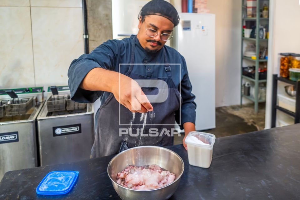 Chef de cozinha e proprietário de restaurante de comida japonesa salgando Polvo