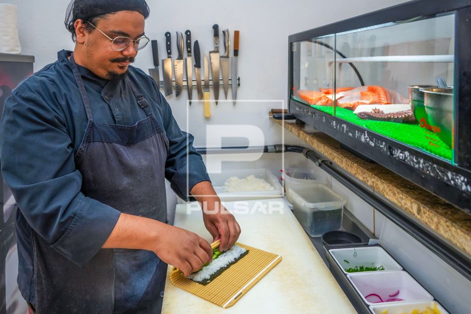 Chef de cozinha e proprietário de restaurante de comida japonesa preparando sushi