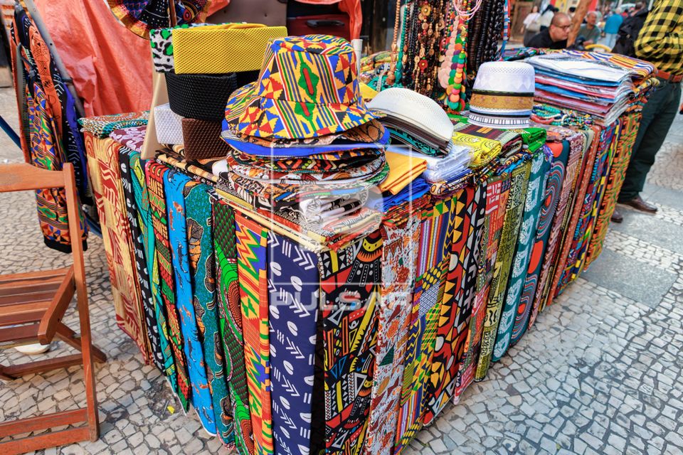 Chapéus e tecidos com padrões coloridos e estampas africanas à venda na região central