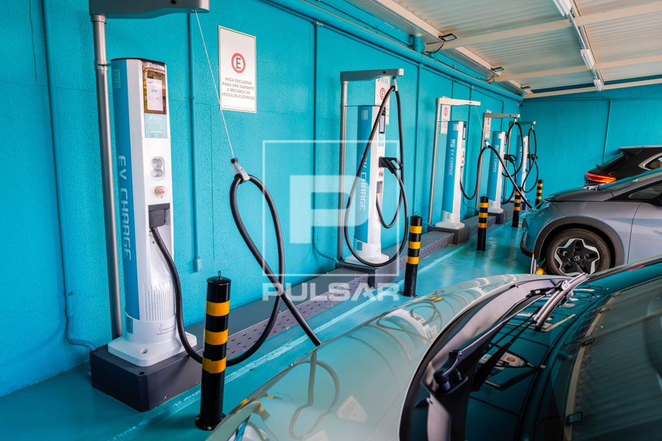 Carros elétricos sendo recarregados em ponto 
