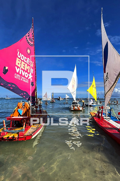 Praia do Porto de Galinhas com banhistas e jangadas nas piscinas naturais formadas pelos arrecifes