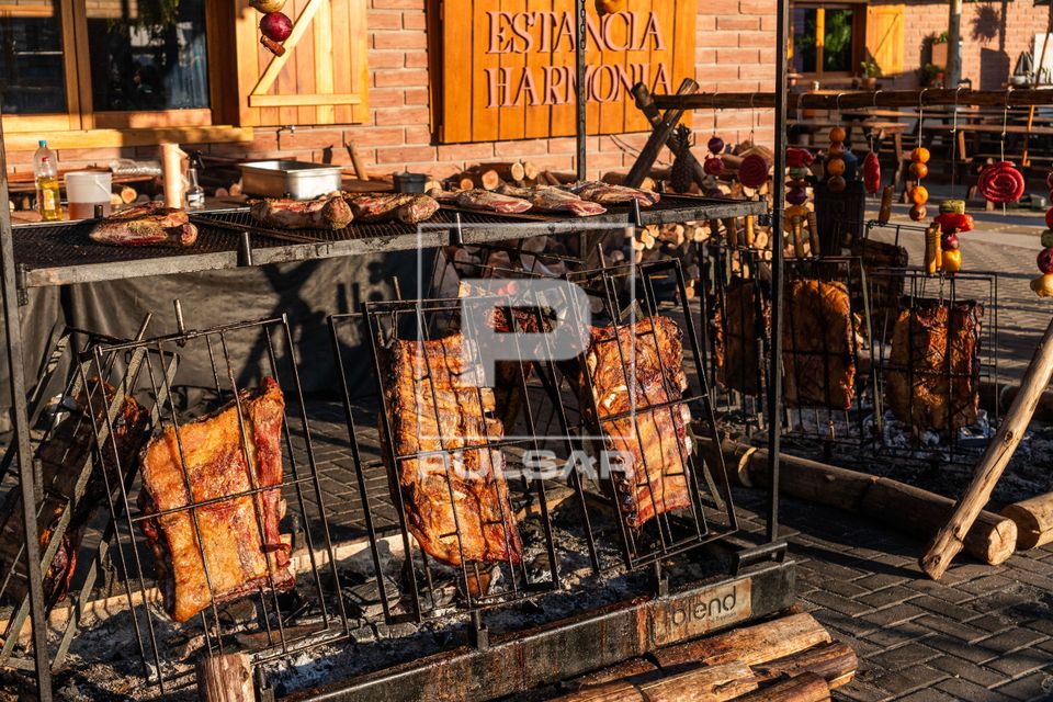Preparação de churrasco no fogo de chão durante as comemorações da Semana Farroupilha no Acampamento Farr