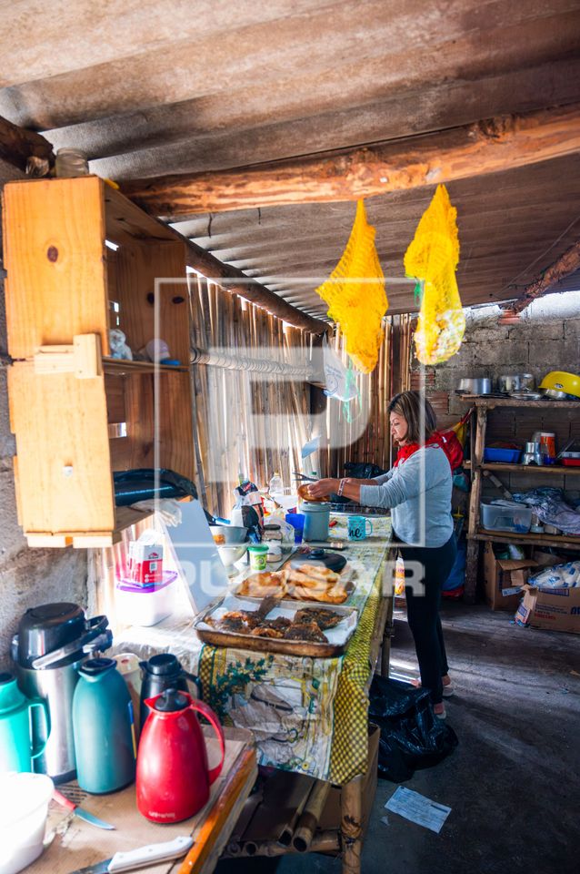Mulher indígena da etnia Guarani Mbya preparando pirá - peixe - e chipá na cozinha da Aldeia de Retomada Nh