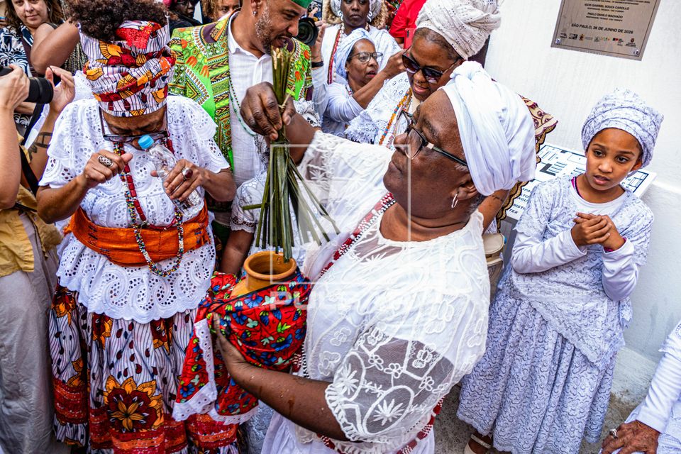 Aspersão de água realizada pelo Babalorixá João de Ossayn do terreiro Ilê Asé Alákétu Ossayn durante a
