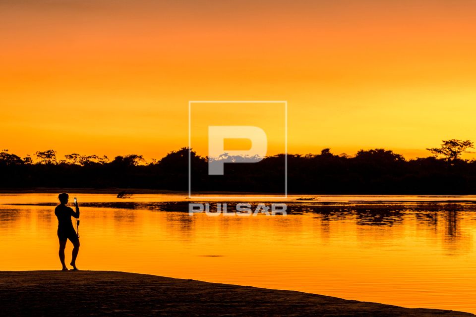 Ecoturista fotografa paisagem ao entardecer no Rio Araguaia