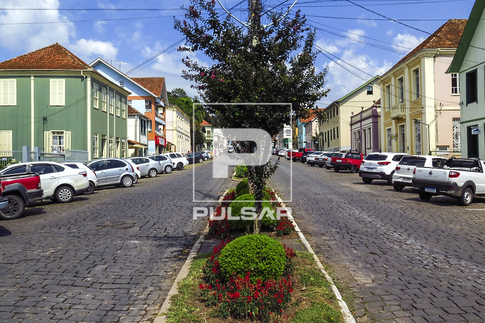 Jardim no canteiro central de rua e casas com arquitetura típica italiana no centro da cidade - 