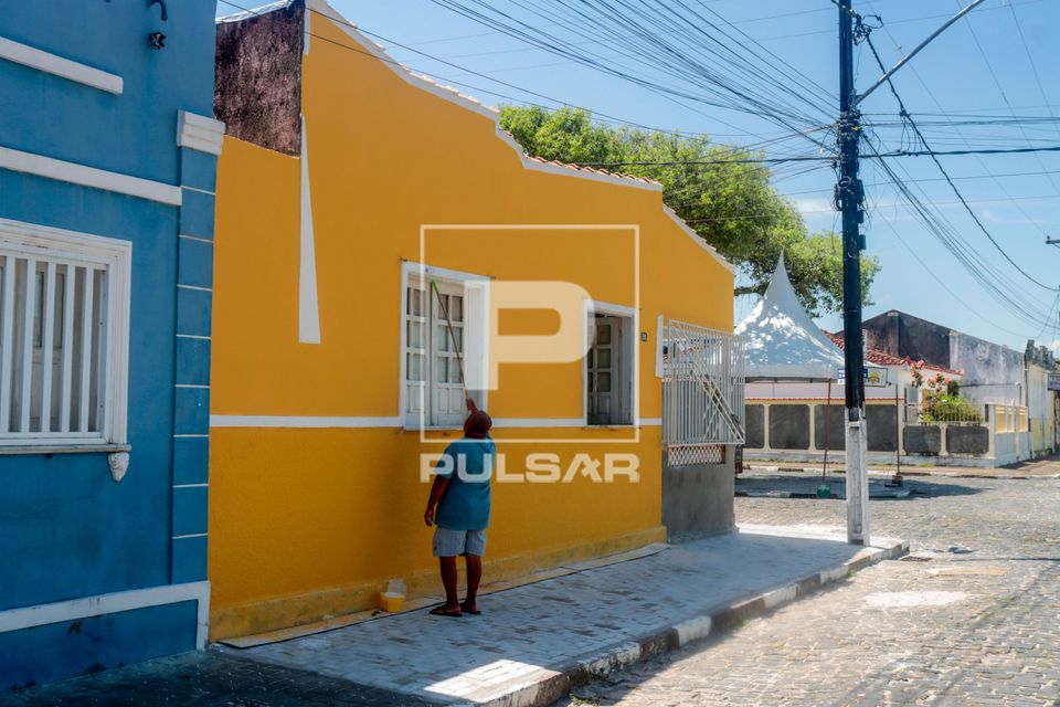 Morador pintando fachada de casa no centro histórico