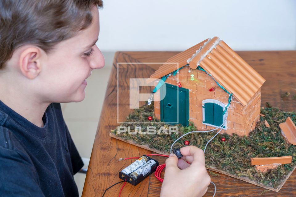 Estudante de 10 anos montando iluminação de uma casa em aula maker