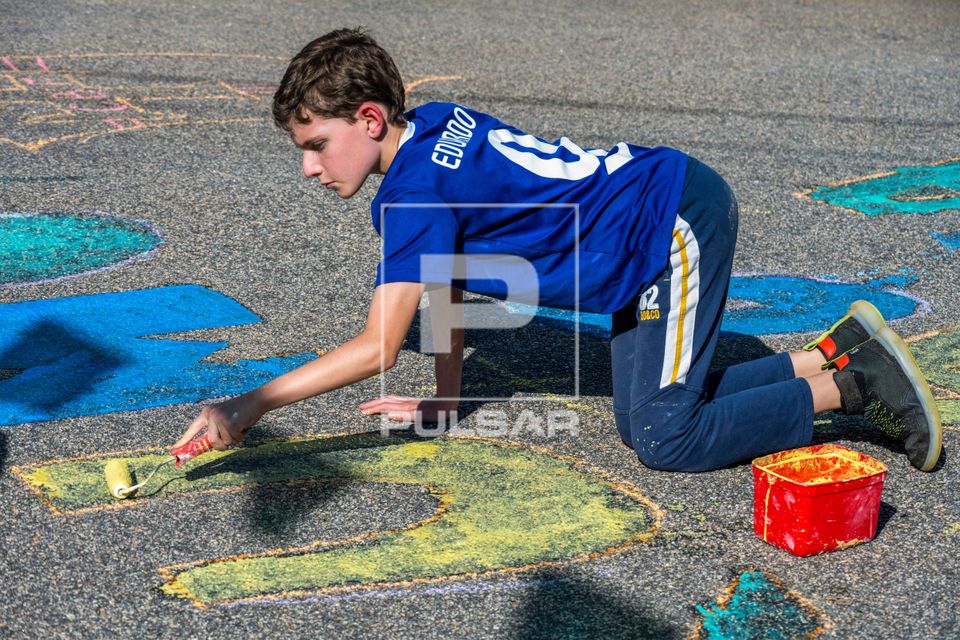 Menino de 10 anos pintando a rua durante os jogos da Copa do Mundo 2026