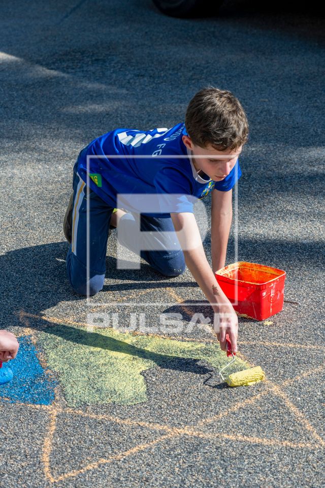Menino de 10 anos pintando a rua durante os jogos da Copa do Mundo 2026