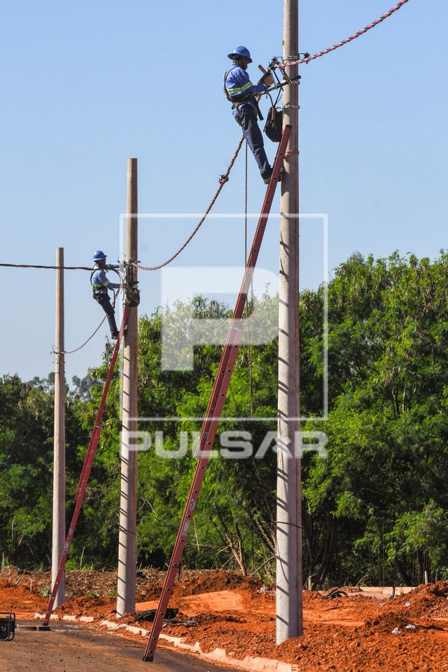 Trabalhadores instalando rede elétrica em novo bairro residencial