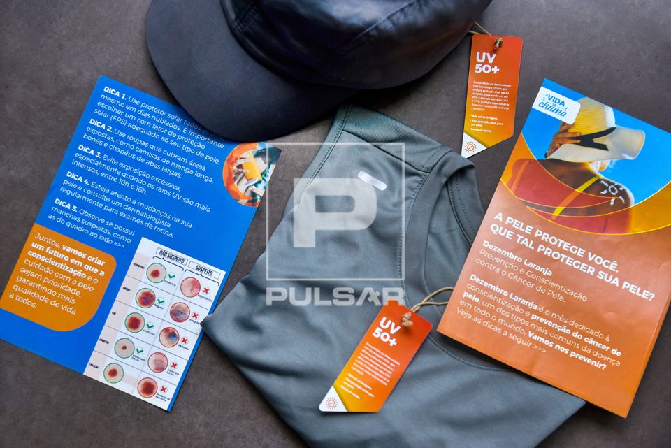 Roupas com tecnologia UV50+ que oferece proteção solar e panfletos com dicas sobre o Dezembro Laranja - mês