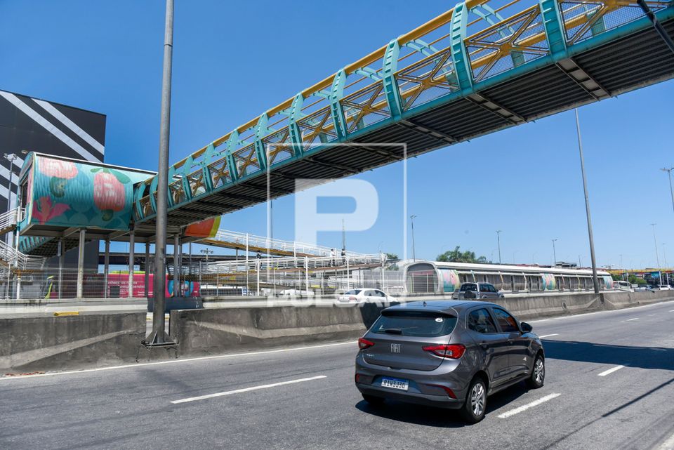 Automóvel sob a passarela para pedestres de acesso a Estação Vasco da Gama do BRT Transbrasil na Avenida Br