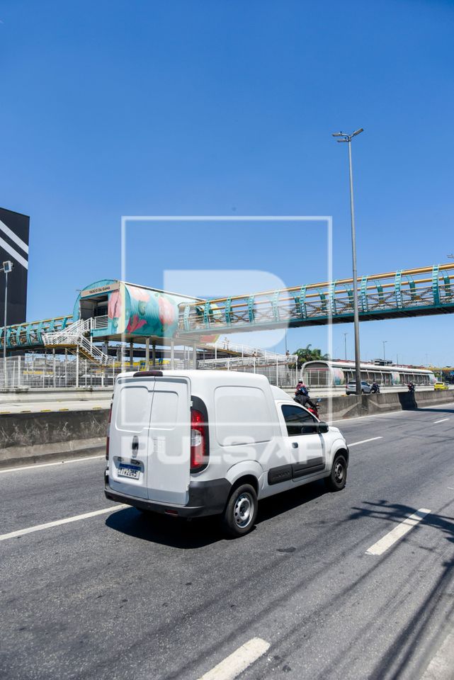Veículo na Avenida Brasil e passarela para pedestres de acesso a Estação Vasco da Gama do BRT Transbrasil