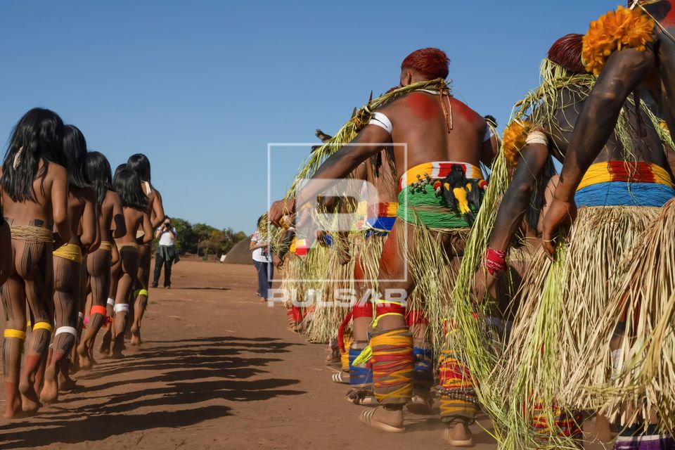 Indígenas Kuikuro da aldeia Ipatse com galhos e saias de palha no ritual de Tawarawana - Parque Indígena do 