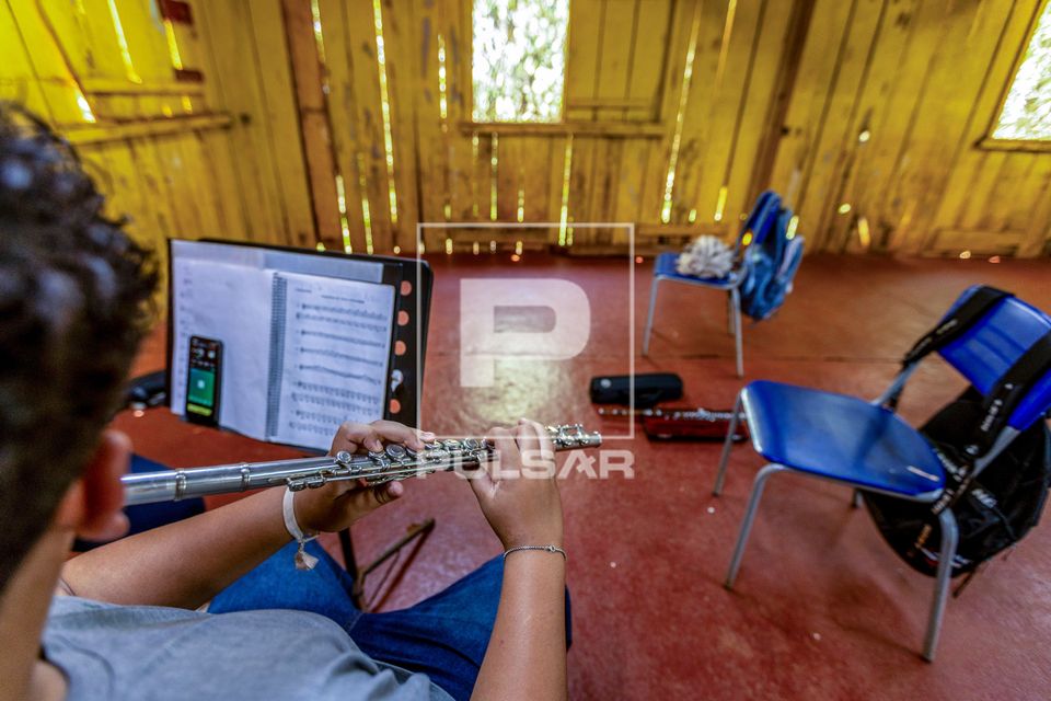 Aluno tocando flauta transversal durante aula de música no Assentamento Eli Vive - MST Movimento dos Trabalha