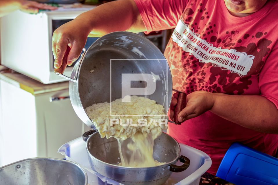 Agricultora drenando coalhada para preparo de queijo artesanal em sua moradia no Assentamento Eli Vive - MST M