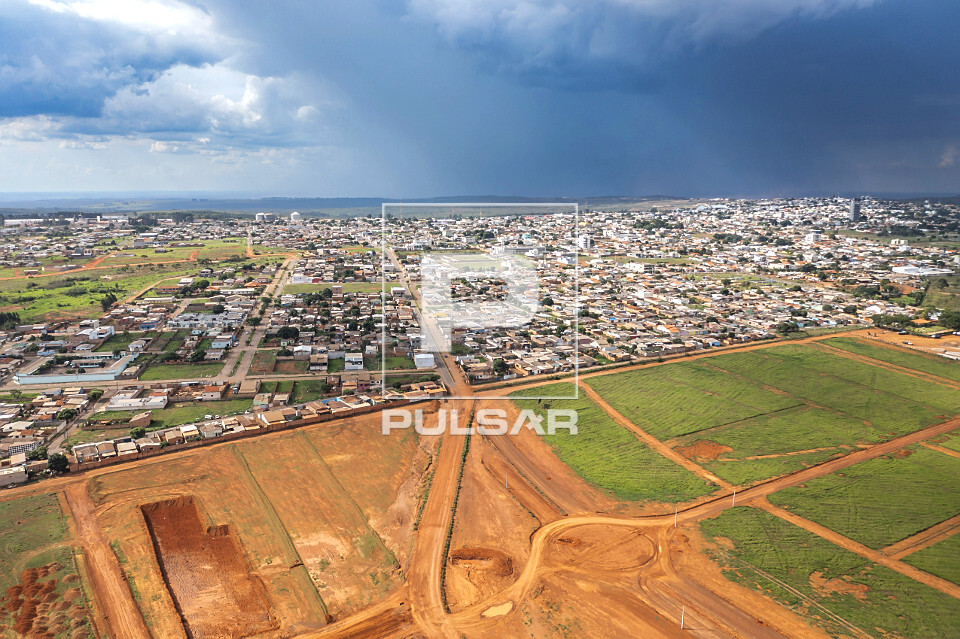 Vista de drone de loteamento e cidade ao fundo - 