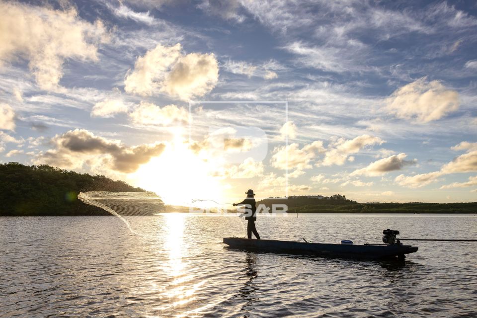 Pesca artesanal com tarrafa no rio Cachoeira ao entardecer