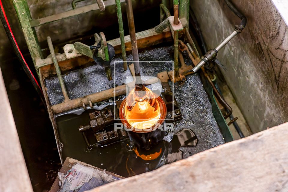 Artista vidreiro sopra uma peça de cristal em alta temperatura - processo artesanal de modelagem - fábrica d