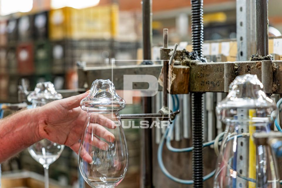 Artesão usa maçarico para corte térmico da borda do copo de cristal - fábrica de cristal
