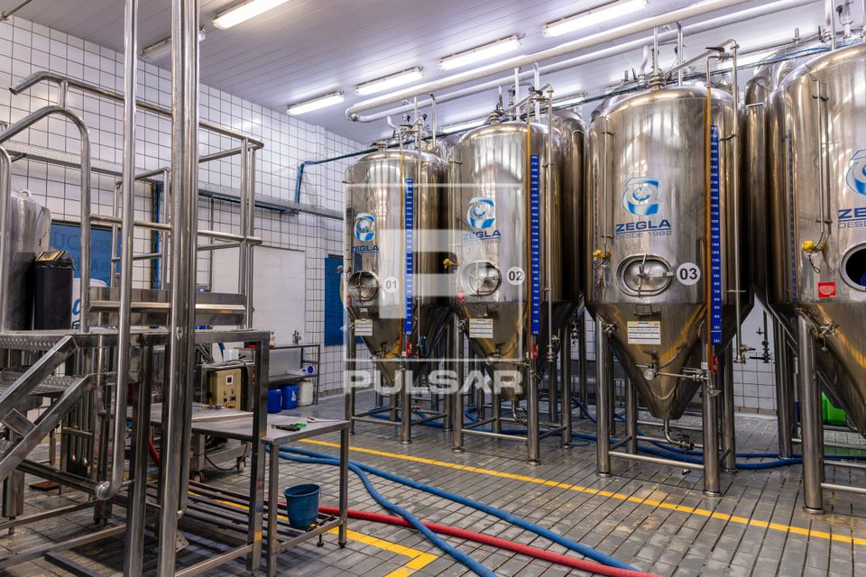Vista interna de cervejaria artesanal - tanques para fermentação em inox
