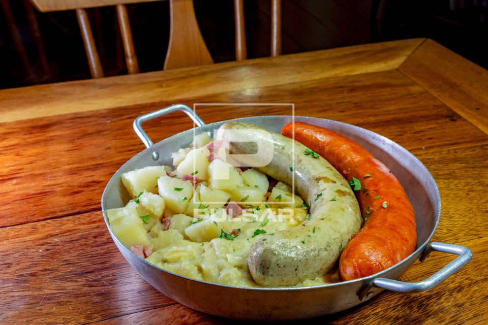 Prato típico da culinária alemã - batatas , salsichas branca e vermelha - servido em restaurante alemão