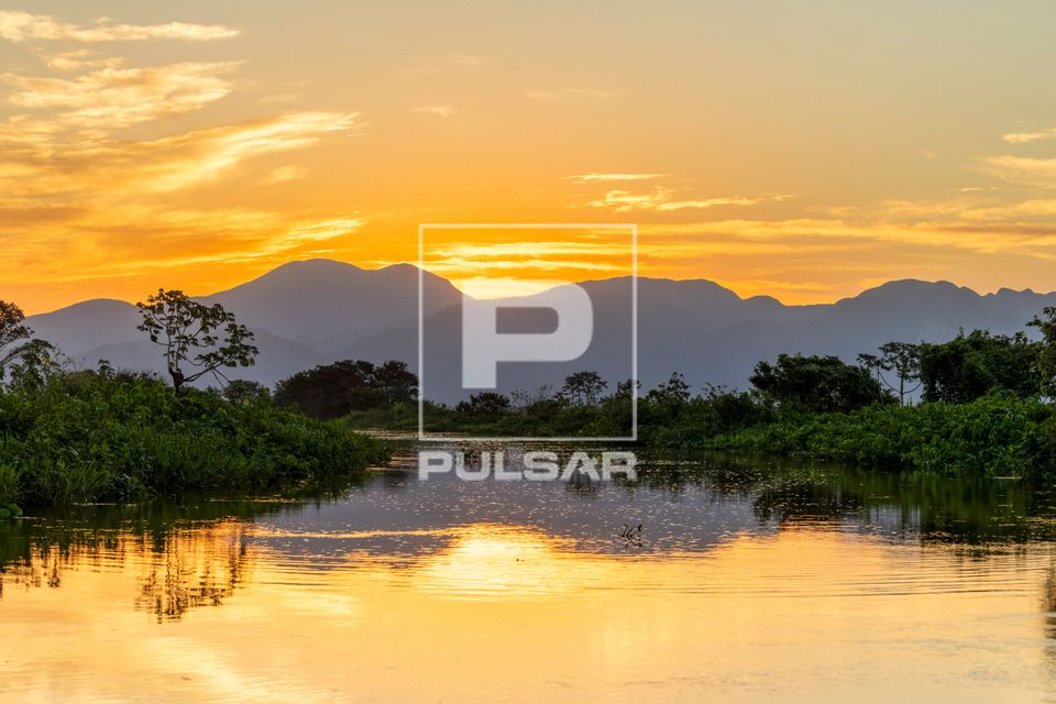 Corixo formado pelas águas do rio Paraguai e ao fundo Serra do Amolar ao entardecer - sub-região Pantanal do