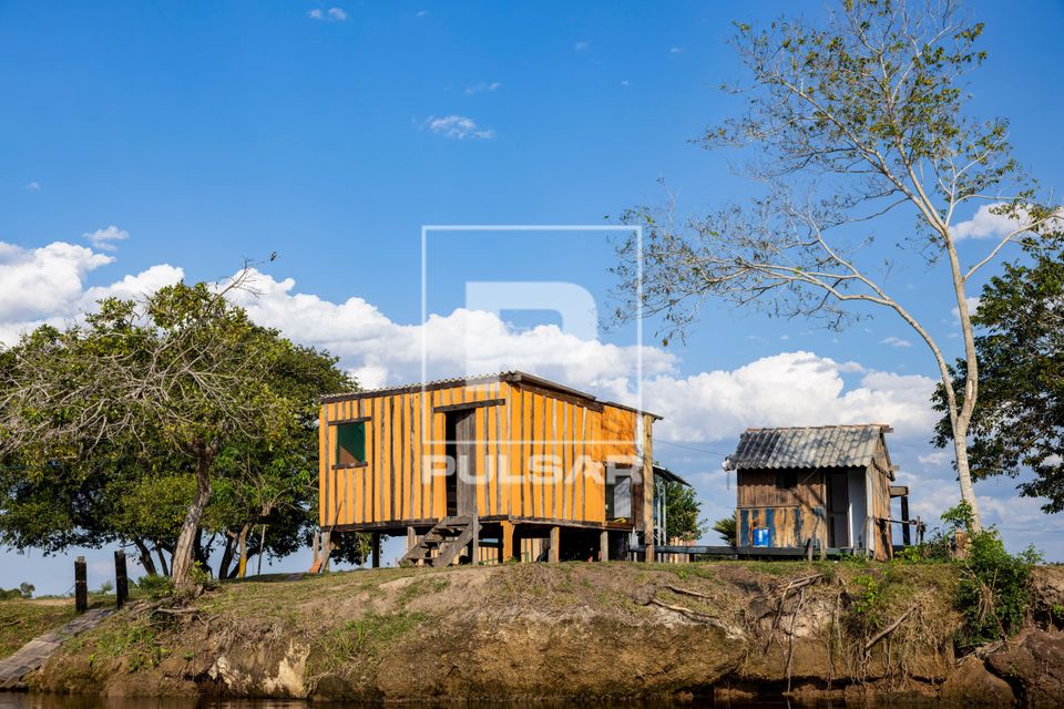 Moradias de ribeirinhos construídas em madeira às margens do Rio Paraguai-Mirim - sub-região Pantanal do Pa