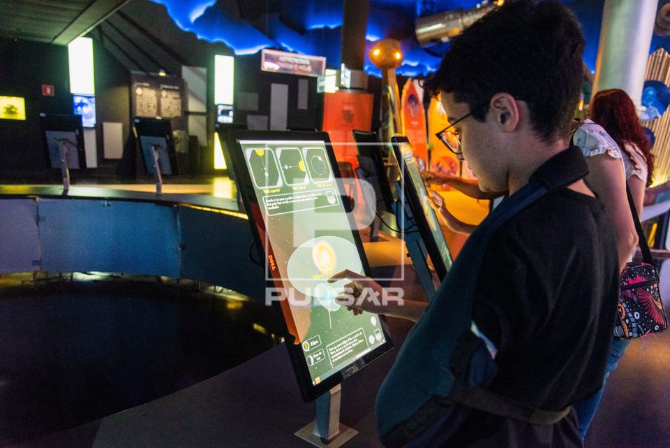 Menino interagindo com painel digital no Museu do Universo no Planetário do Rio