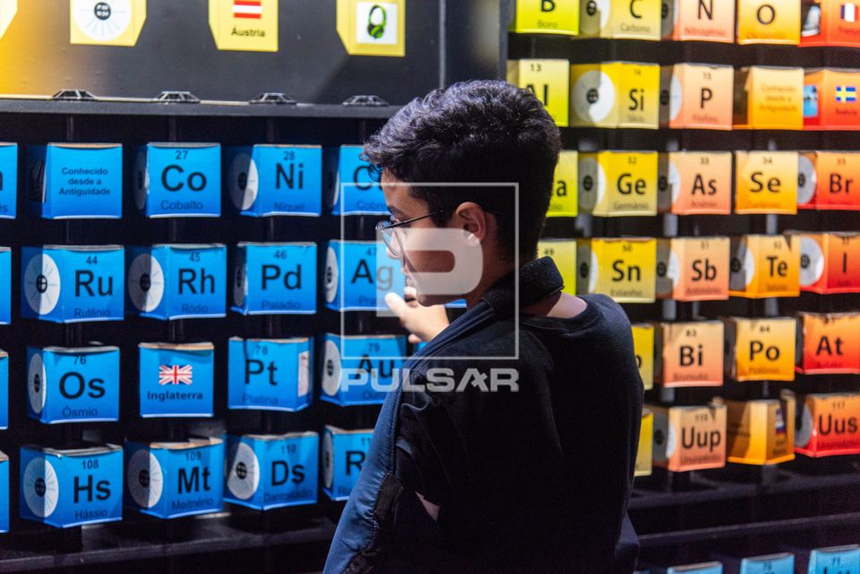 Menino interagindo com tabela periódica dos elementos no Museu do Universo no Planetário do Rio