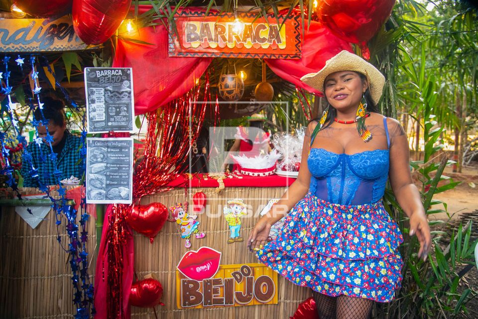 Indígena da etnia Kaapor posando em frente a barraca do beijo na festa junina na aldeia urbana multiétnica M