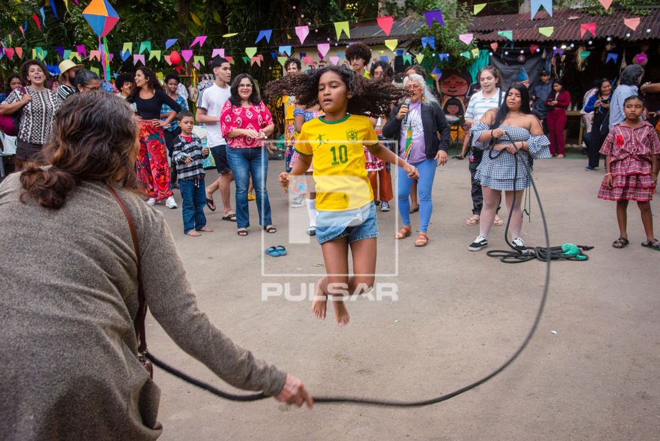 Menina adolescente afro indígena brincando de pula coorda na festa junina na aldeia urbana multiétnica Marac