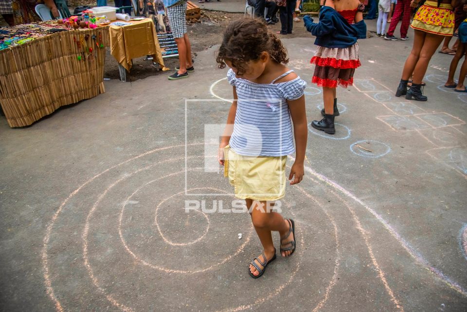 Menina brinca em labirinto de giz durante festa junina na aldeia urbana multiétnica Maracanã ou Marakanã