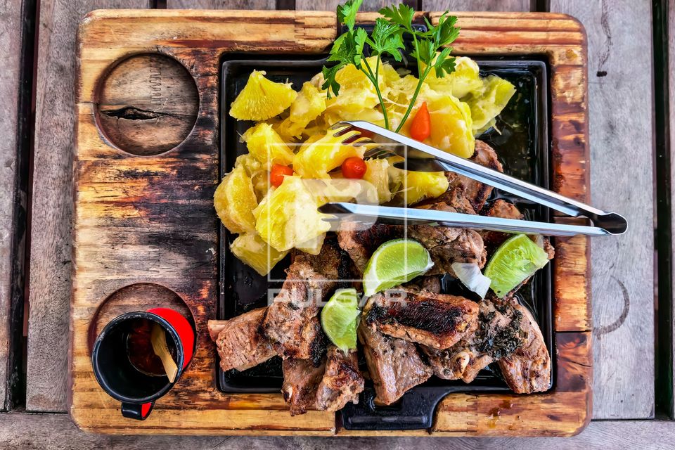 Porção de costelinha de porco e macaxeira cozida servida em restaurante