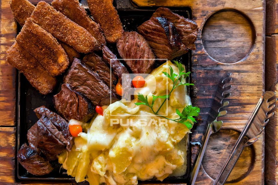 Carne de sol acompanhada de banana-da-terra frita e macaxeira cozida servido em restaurante