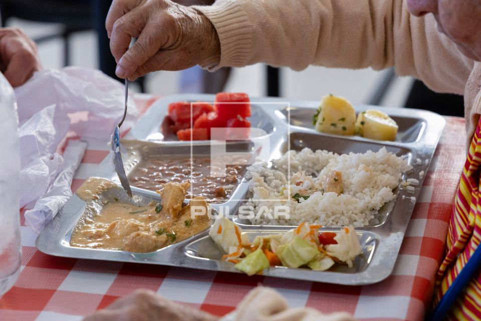 Pessoa se alimentando com arroz feijão strogonoff de frango salada de repolho batata cozida e melancia no res