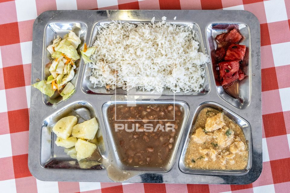 Bandeja com arroz feijão carne de frango salada de repolho batata cozida e melancia servida no restaurante de
