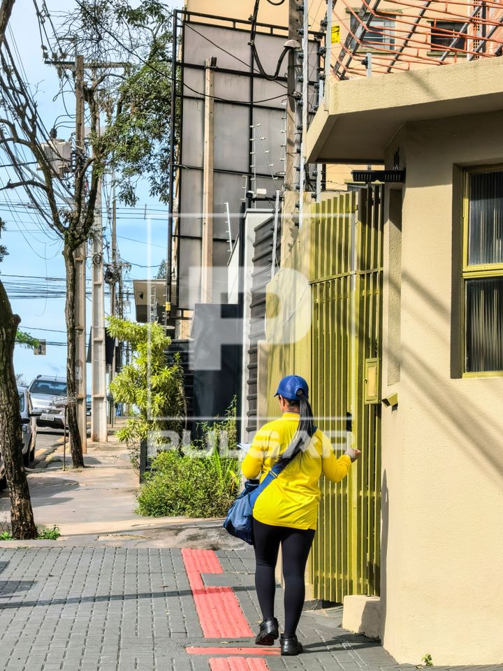 Carteira dos correios entregando correspondência em prédio residencial - centro da cidade