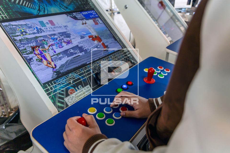 Pessoa jogando videogame em máquina de fliperama na 22ª edição do Festival Londrina Matsuri - festa da cul