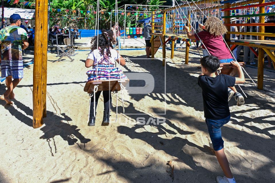 Crianças brincando em balanço durante festa junina na Escola Municipal Agostinho Ferreira Mattos na Praia da