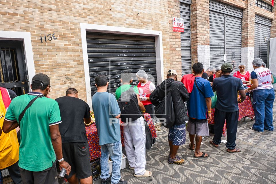 Voluntários do projeto Povo do Pão da Rua servindo refeição durante a Festa do Divino - bairro da Luz