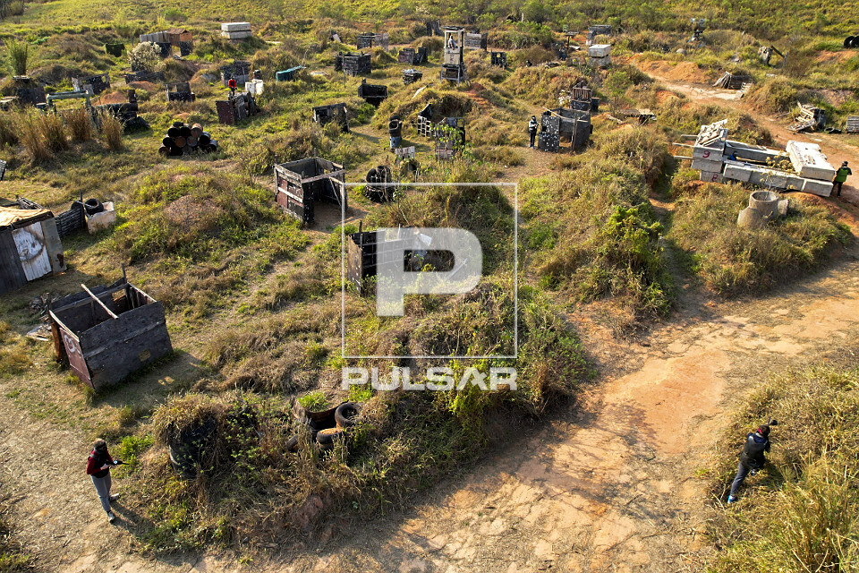 Vista de drone de adolescentes brincando de paintball - esporte de combate em equipe que atira bolas de tinta 