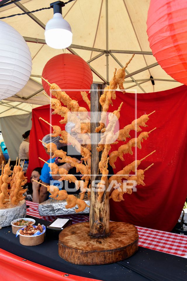 Espetos com camarões fritos à venda em banca de comida típica indonésia no Festival Sabores e Luzes da Cor