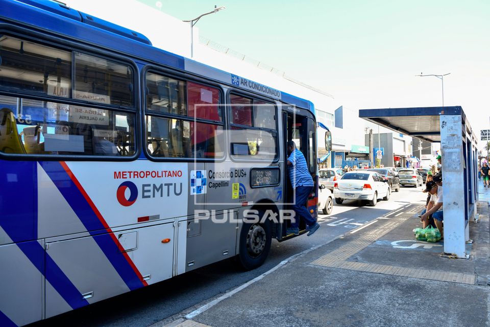 Embarque de passageiro em ponto de ônibus no centro da cidade