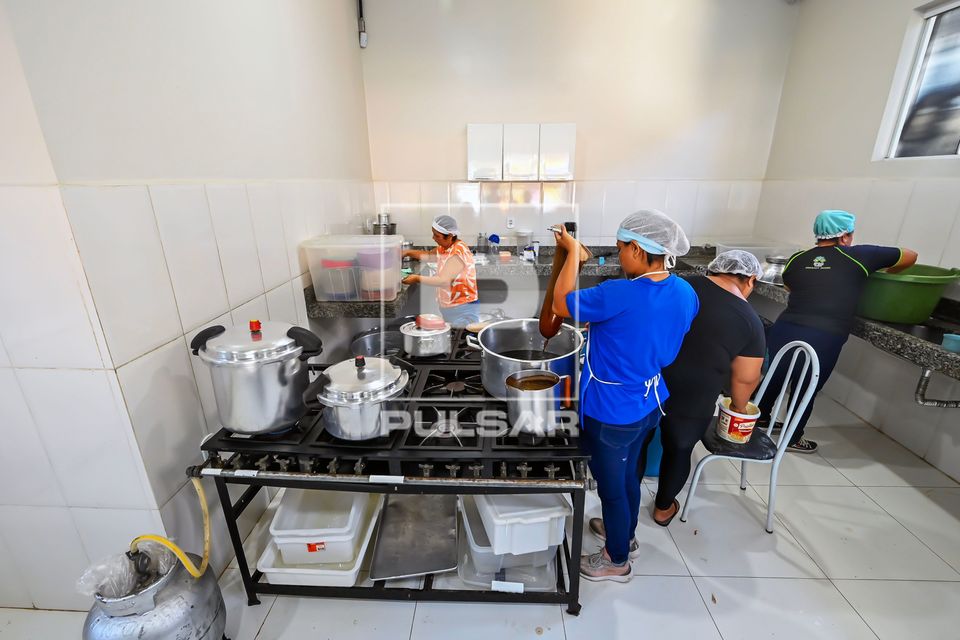 Merendeira coando café e trabalhadoras na cozinha da Escola Estadual Coaracy Nunes de ensino médio e fundame