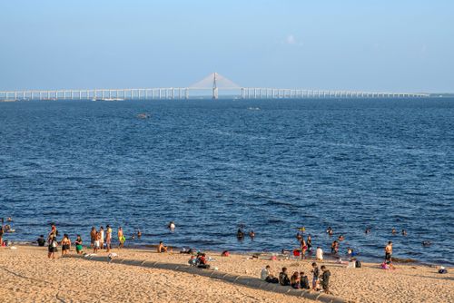 Banhistas na Praia da Ponta Negra ao fundo Ponte Estaiada Jornalista Phelippe Daou - Rodovia Manuel Urbano sob