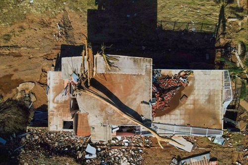 Vista de drone de moradia destruída com tronco de árvore no teto após a enchente no Vale do Taquari