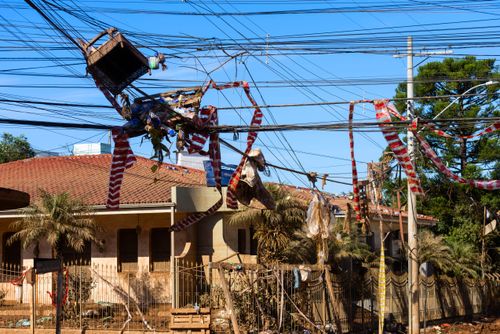 Lixo e objetos transportados pela correnteza da enchente retidos na rede elétrica - Vale do Taquari