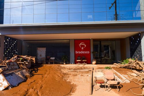 Agência bancária retirando lama e destroços após enchentes no Vale do Taquari